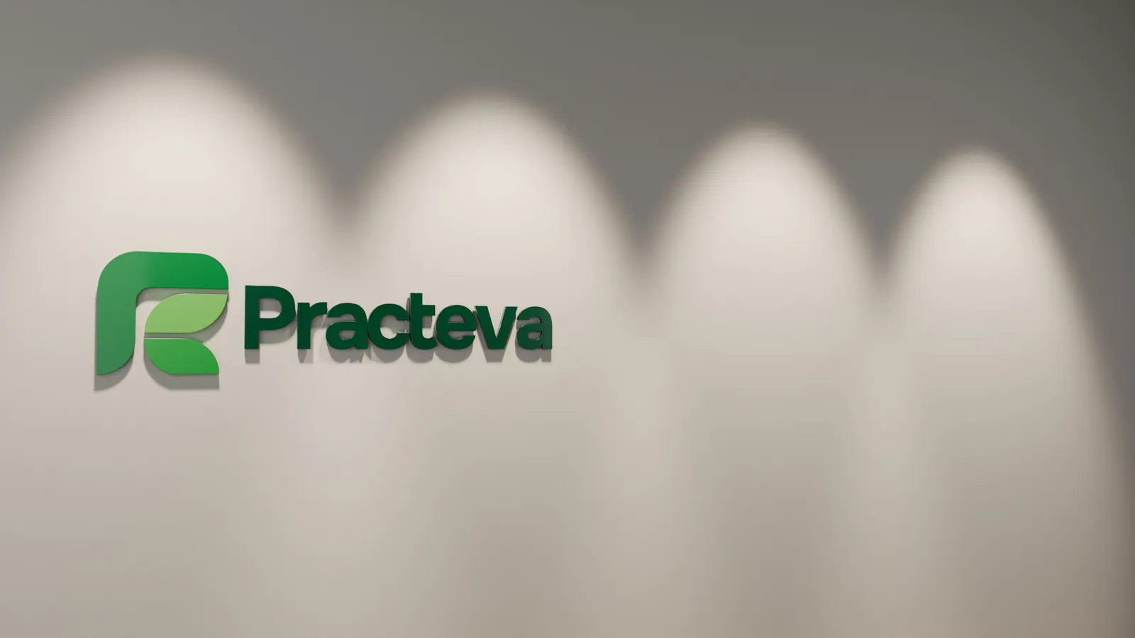 The Practeva logo as a sign on a softly lit wall